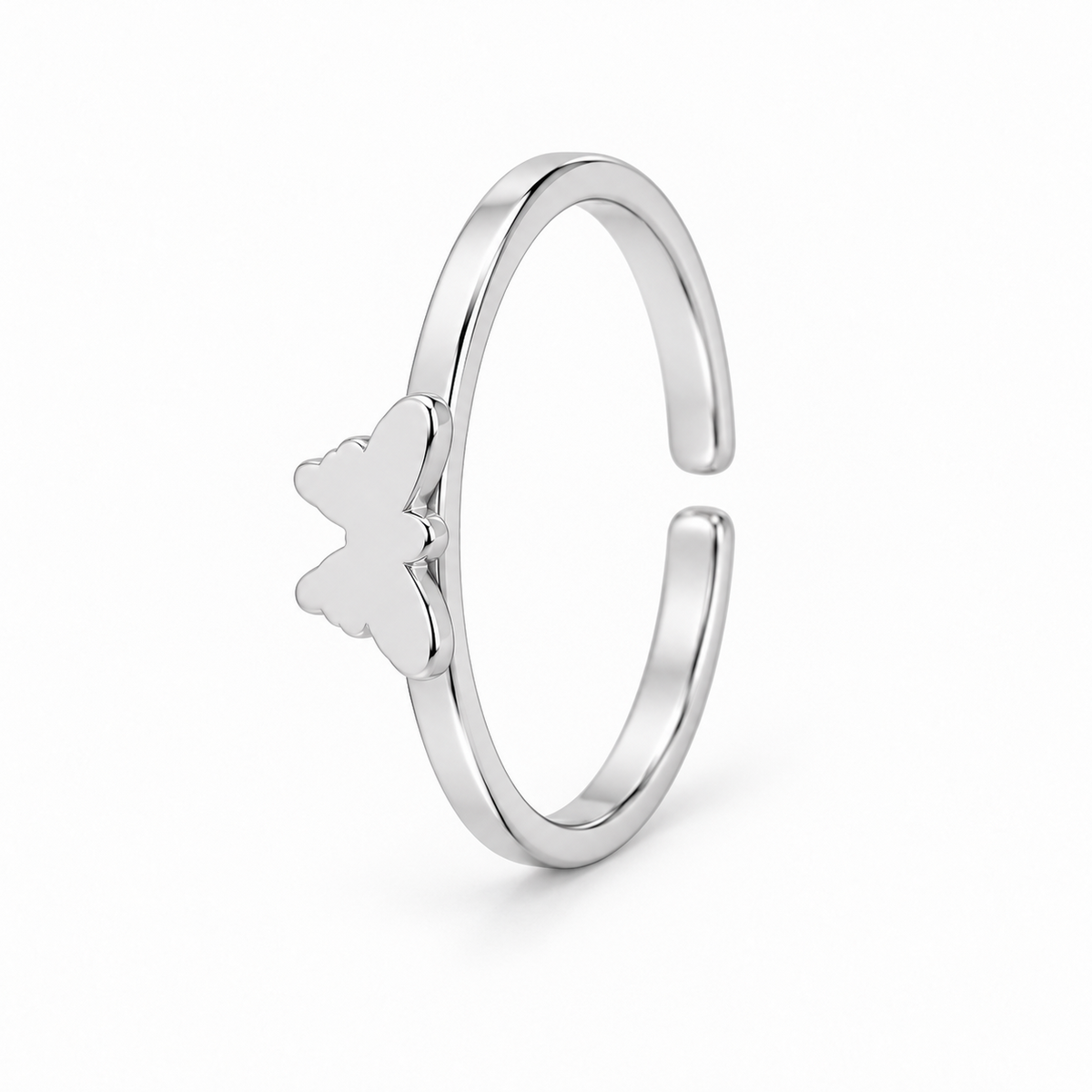 Anillo abierto plateado con una mariposa lisa sobre un aro fino, vista en perspectiva sobre fondo blanco.